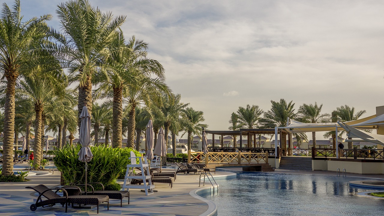 A swimming pool surrounded by palm trees in Bahrain, representing things to pay attention to when renting an apartment in Bahrain